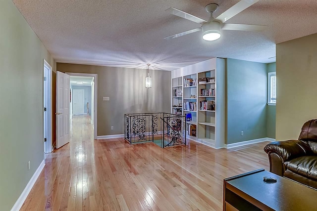 interior space featuring ceiling fan, light hardwood / wood-style floors, and a textured ceiling