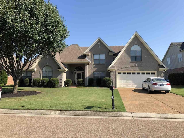 view of front of property with a front lawn and a garage