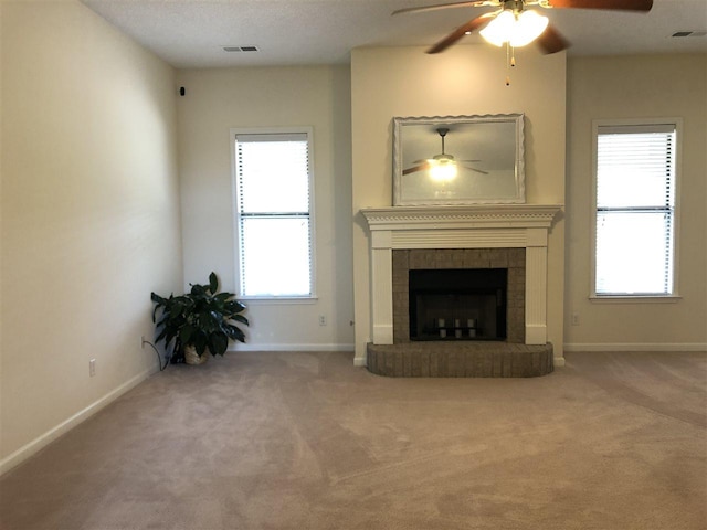 unfurnished living room with ceiling fan, carpet flooring, and a fireplace