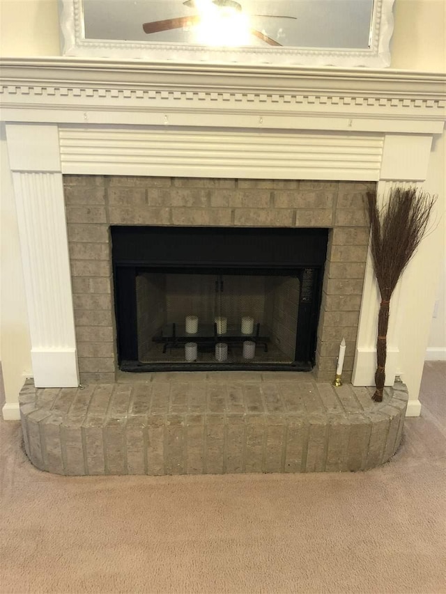 interior details with ceiling fan, a fireplace, and carpet floors