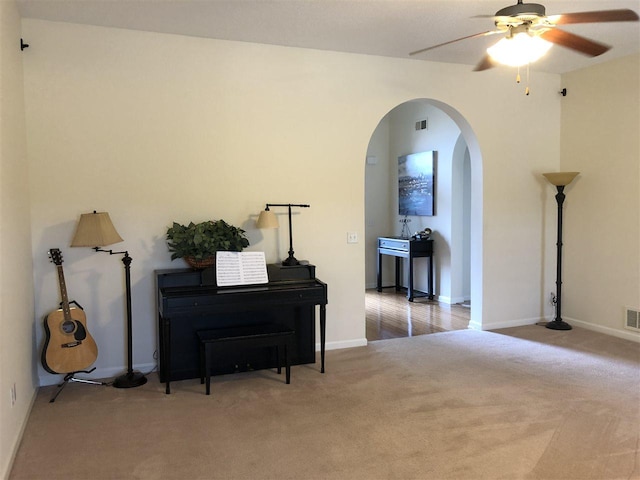 misc room with ceiling fan and dark colored carpet