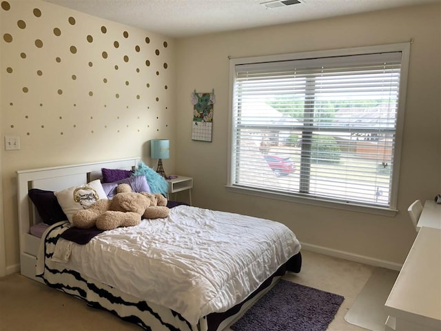 carpeted bedroom featuring multiple windows and a textured ceiling