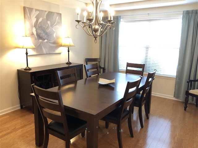 dining area with an inviting chandelier and light wood-type flooring