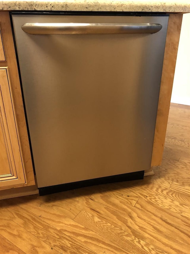 room details with light hardwood / wood-style floors and stainless steel dishwasher