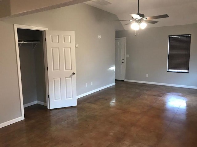 interior space with lofted ceiling, dark tile flooring, ceiling fan, and a closet