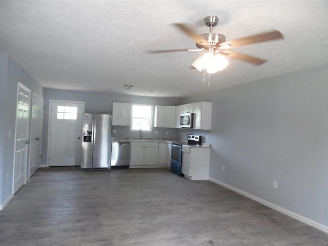 kitchen featuring white cabinets, appliances with stainless steel finishes, plenty of natural light, and hardwood / wood-style floors