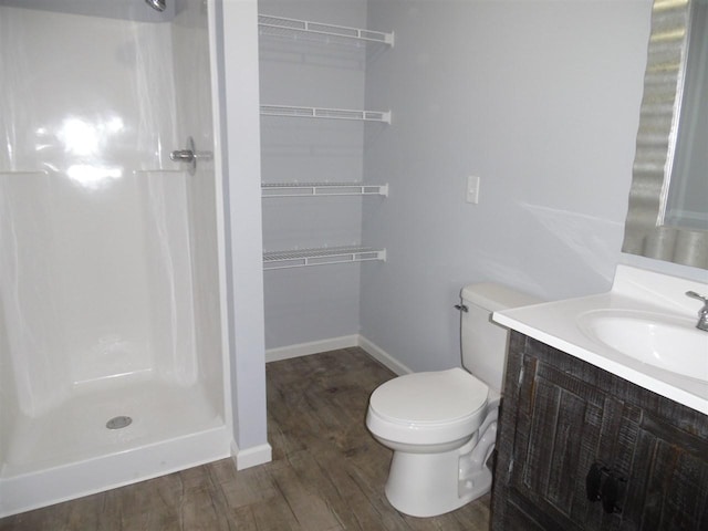 bathroom with walk in shower, toilet, hardwood / wood-style floors, and vanity