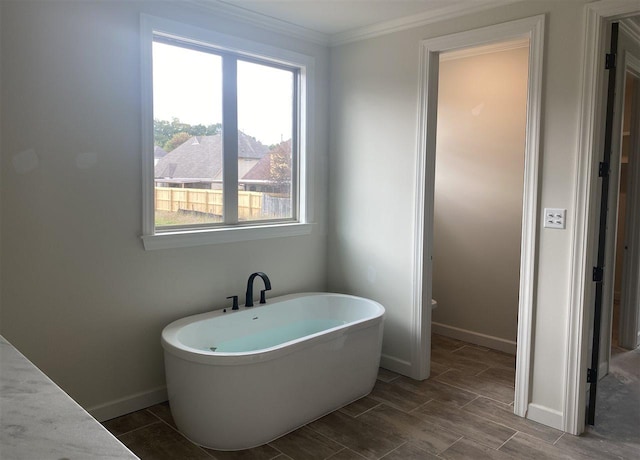 bathroom with a bath to relax in and crown molding