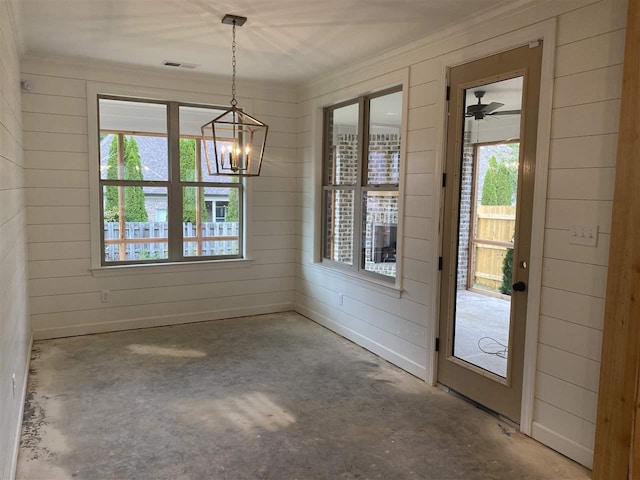 unfurnished dining area featuring ceiling fan with notable chandelier