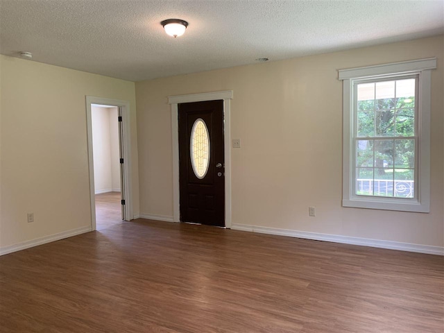 foyer featuring dark hardwood / wood-style floors and a textured ceiling