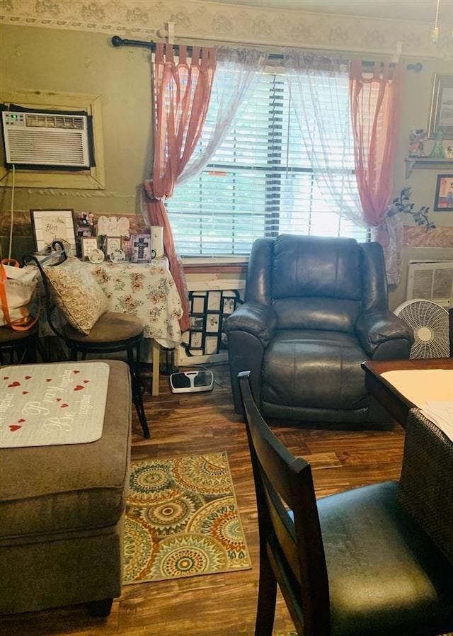 bedroom featuring multiple windows, wood-type flooring, and a wall unit AC