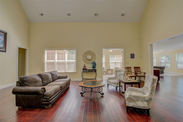 living room with dark hardwood / wood-style flooring and a towering ceiling