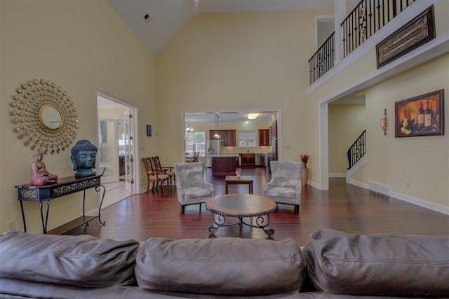 living room with dark wood-type flooring and high vaulted ceiling