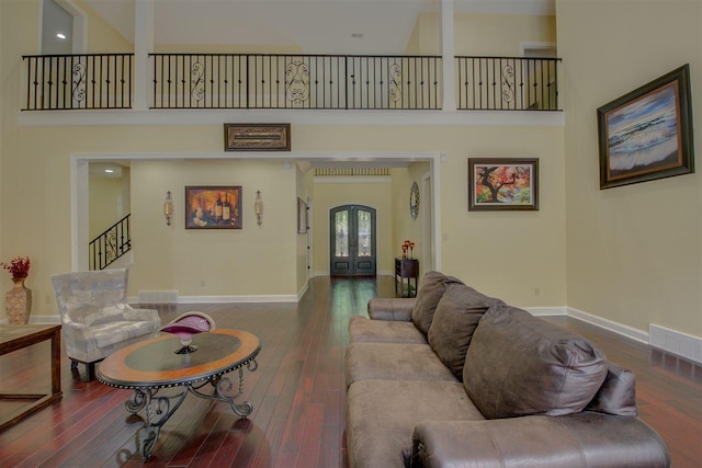 living room with dark hardwood / wood-style floors and a high ceiling