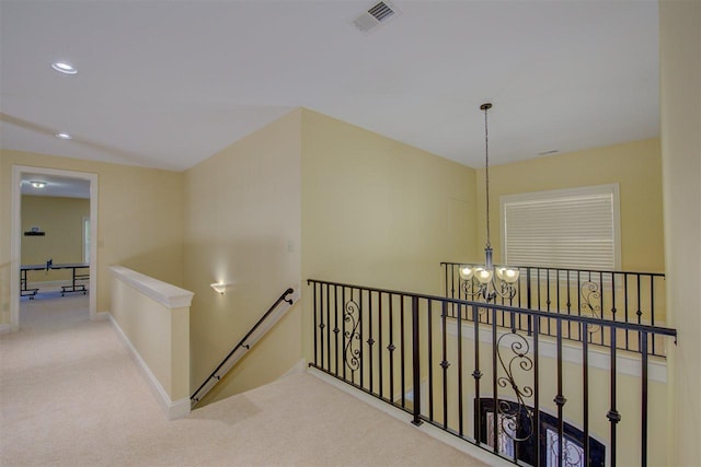 hallway with a notable chandelier and light carpet