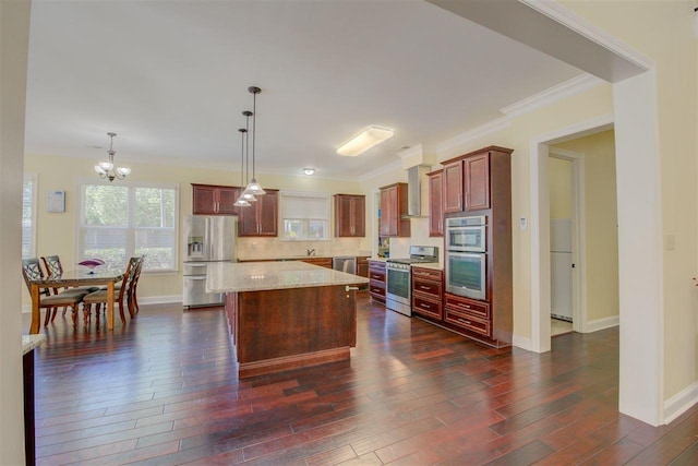 kitchen with decorative light fixtures, an inviting chandelier, stainless steel appliances, a kitchen island, and tasteful backsplash