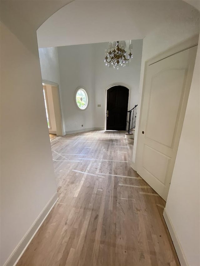 hall featuring an inviting chandelier and light hardwood / wood-style floors