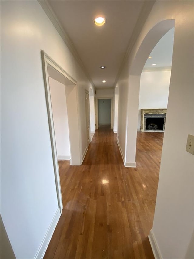 hallway featuring dark wood-type flooring and crown molding