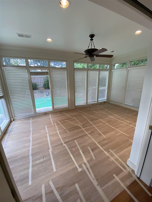 unfurnished sunroom with ceiling fan