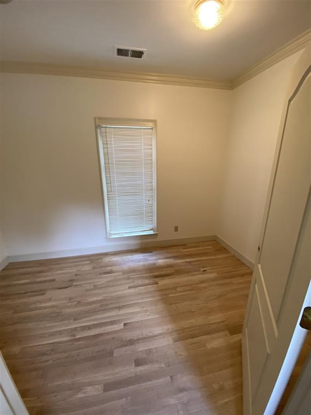 unfurnished room featuring light wood-type flooring and crown molding