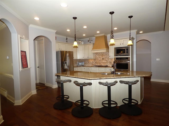 kitchen featuring pendant lighting, stainless steel appliances, custom exhaust hood, dark hardwood / wood-style flooring, and light stone counters