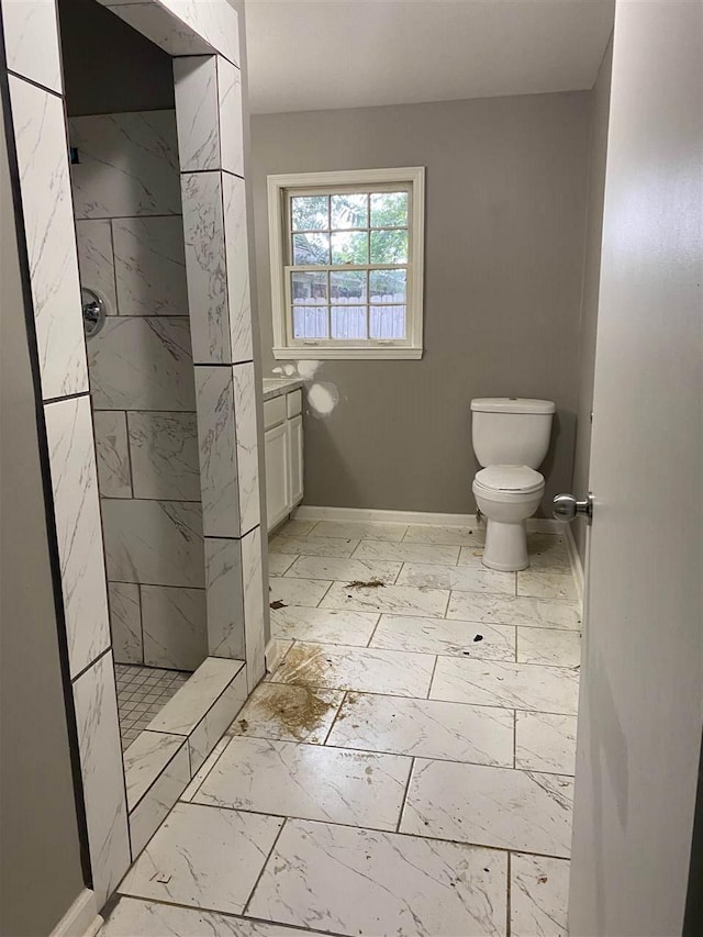 bathroom with toilet, tile flooring, a tile shower, and vanity