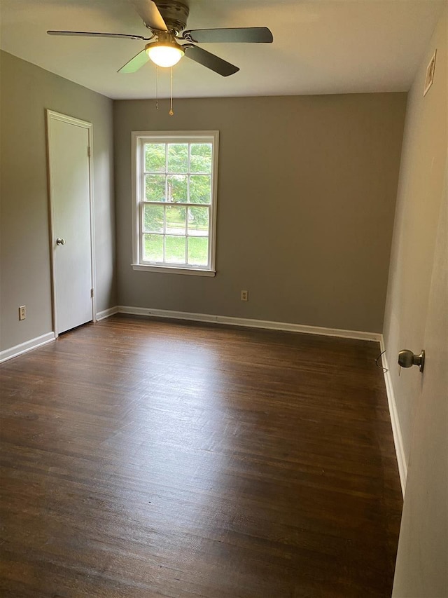 spare room with ceiling fan and dark wood-type flooring