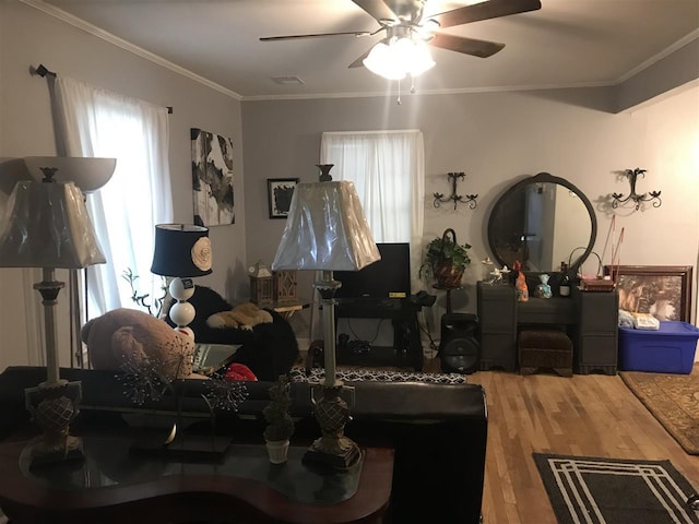 living room with hardwood / wood-style floors, ceiling fan, and crown molding