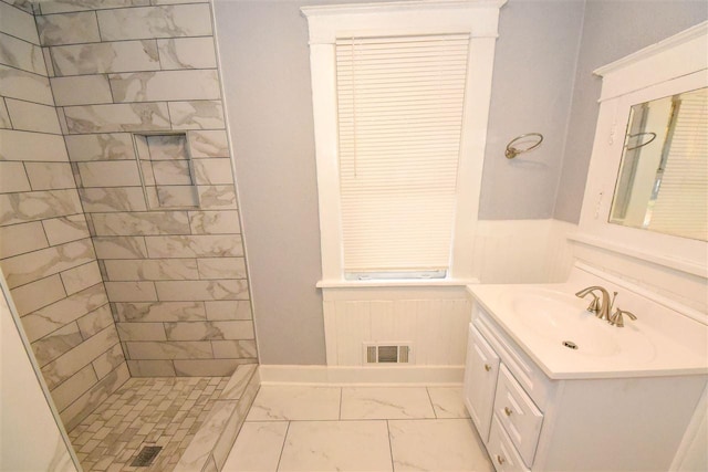 bathroom with large vanity, tile floors, and tiled shower