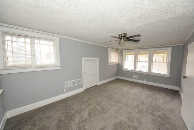 carpeted spare room featuring plenty of natural light, crown molding, a textured ceiling, and ceiling fan