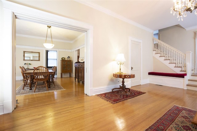 interior space featuring light hardwood / wood-style flooring, crown molding, and an inviting chandelier