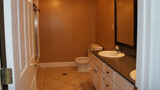 bathroom featuring tile floors, vanity with extensive cabinet space, and toilet