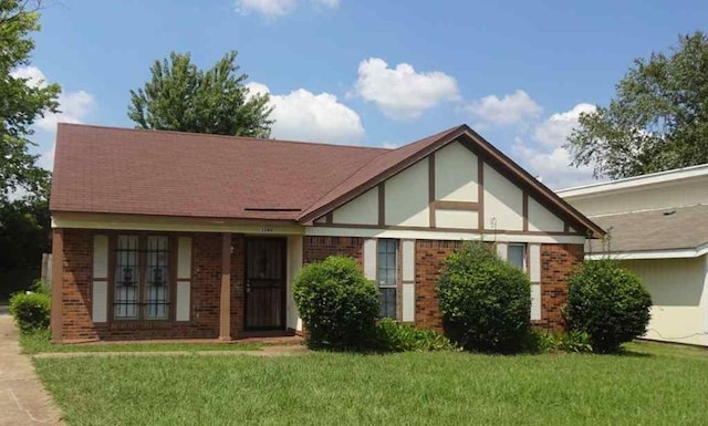 english style home with a front yard