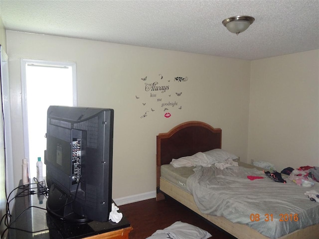 bedroom featuring a textured ceiling and dark wood-type flooring