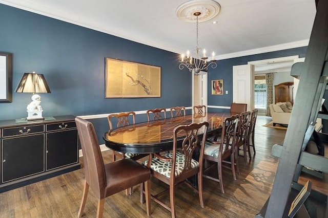 dining space with ornamental molding, dark wood-type flooring, and a chandelier