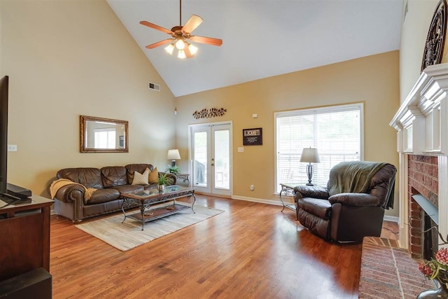 living room featuring ceiling fan, a healthy amount of sunlight, a fireplace, and french doors