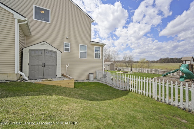 4246 Black Cherry Ln, Mason, MI 48854 - fenced yard with a storage shed and a playground