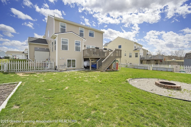 4246 Black Cherry Ln, Mason, MI 48854 - back of property with an outdoor fire pit, a deck, stairway, a fenced backyard, and a residential view