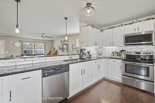 4246 Black Cherry Ln, Mason, MI 48854 - kitchen featuring stainless steel appliances, dark stone countertops, backsplash, and white cabinetry