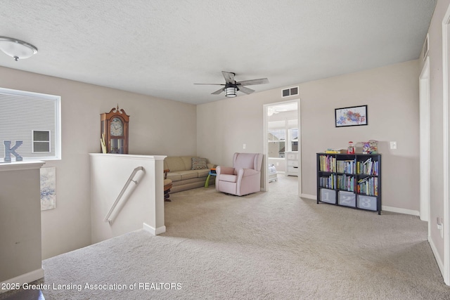 4246 Black Cherry Ln, Mason, MI 48854 - living area featuring a ceiling fan, carpet, an upstairs landing, and a textured ceiling