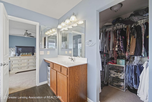 4246 Black Cherry Ln, Mason, MI 48854 - bathroom with vanity, ceiling fan, wood finished floors, and a walk in closet