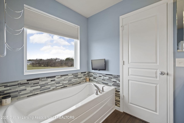 4246 Black Cherry Ln, Mason, MI 48854 - bathroom featuring a garden tub and wood finished floors