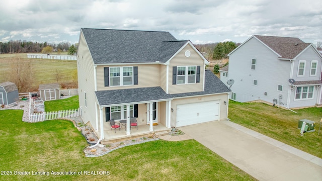 4246 Black Cherry Ln, Mason, MI 48854 - traditional-style house featuring a porch, a shingled roof, driveway, a storage shed, and a garage