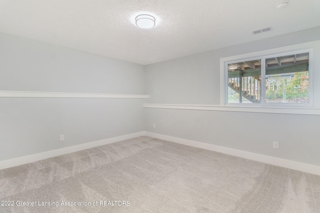 carpeted spare room with a textured ceiling