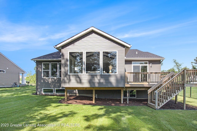 rear view of house featuring a wooden deck and a yard