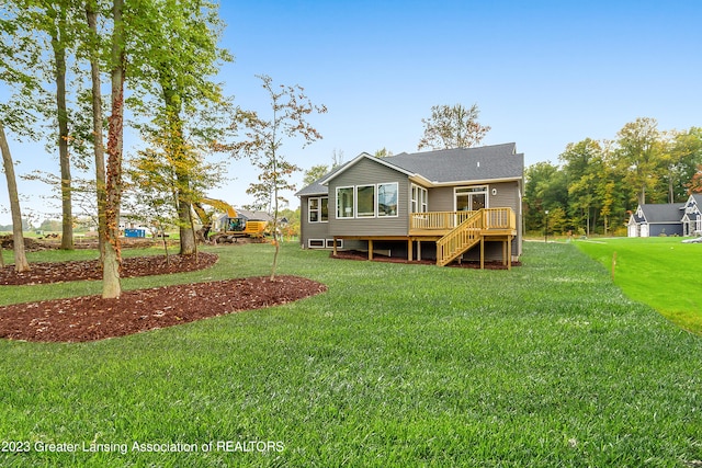 back of property with a deck and a yard