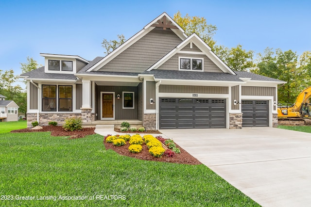 craftsman house with a front lawn, a porch, and a garage