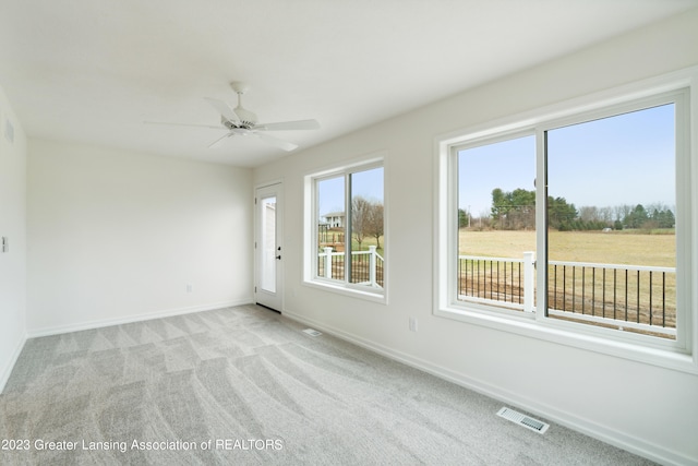 carpeted spare room with ceiling fan