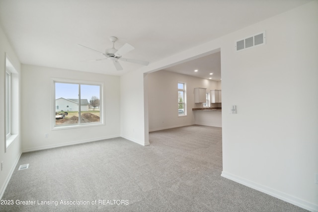 empty room with ceiling fan and light colored carpet