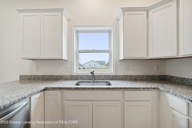 kitchen featuring white cabinetry, sink, light stone countertops, and dishwasher